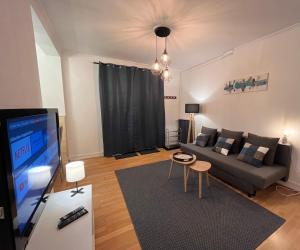 a living room with a couch and a flat screen tv at La Belle Endormie - Louez L'Esprit Libre ! in Champs-sur-Marne