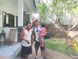 two men and a child standing in front of a house at BUKIT GARDEN in Mataram