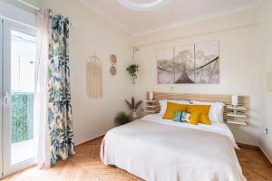 アテネにあるCozy apartment in Athensのベッドルーム(白い大型ベッド、黄色い枕付)