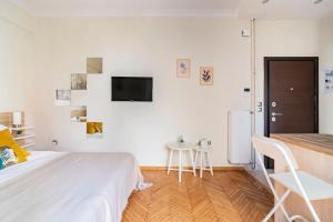 アテネにあるCozy apartment in Athensの白いベッドルーム(ベッド1台、テーブル付)