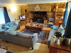 Langoëlan的住宿－Chestnut，带沙发和石制壁炉的客厅