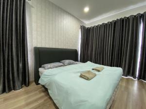 a bedroom with a bed with two towels on it at Homestay P residence 3 bedroom and 2 bathroom in Kuching