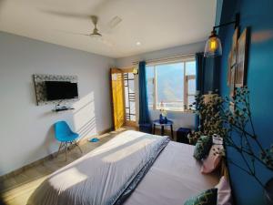 a bedroom with a bed and a blue wall at Blue Hills- B&B McleodGanj in Dharamshala