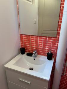 La salle de bains est pourvue d'un lavabo blanc et d'un miroir. dans l'établissement Vivez ZEN - Entre la gare et l'Hotel de ville, au Havre