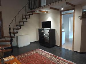 a living room with a staircase and a television at SUNNY APARTMENT NORTHERN ATHENS in Athens