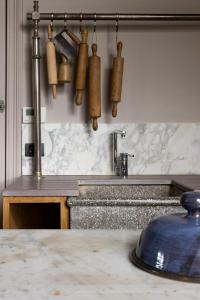 um balcão de cozinha com um lavatório e alguns utensílios de cozinha em vakantiehuis ter poele em Avelgem