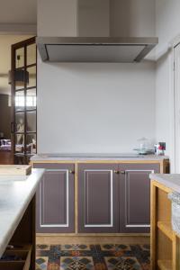 a kitchen with gray cabinets and a stove top oven at vakantiehuis ter poele in Avelgem +15 photos