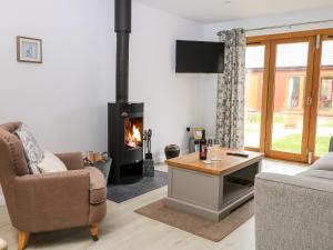 a living room with a fireplace and a couch and a table at Rabbit's Warren in Warsash