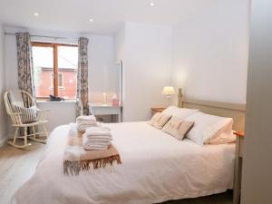 a bedroom with a white bed with towels on it at Rabbit's Warren in Warsash