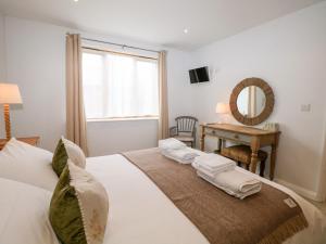 Un dormitorio con una gran cama blanca y una mesa en Fox's Den en Fareham