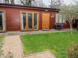 a wooden house with a yard with a lawn sidx sidx sidx at Fox's Den in Fareham