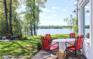 uma mesa e cadeiras num alpendre com vista para um lago em 3 Bedroom Awesome Home In rebro em Örebro