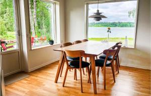 einen Esstisch mit Stühlen und ein großes Fenster in der Unterkunft 3 Bedroom Awesome Home In rebro in Örebro