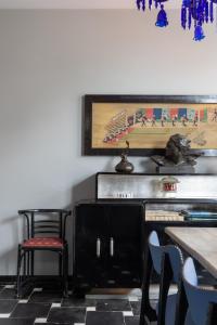 uma sala de jantar com uma mesa e cadeiras e um quadro em vakantiehuis ter poele em Avelgem
