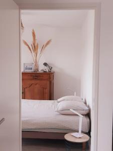 a bedroom with a bed with a wooden headboard at Logement neuf dans résidence calme parking gratuit in La Rochelle