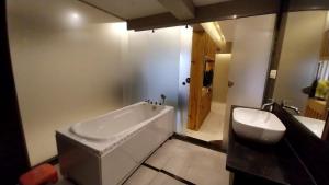 a bathroom with a large tub and a sink at Hotel Merakee - Near Dahisar Mira Road Mumbai in Mumbai
