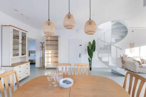 Il comprend une cuisine et une salle à manger avec une table et des chaises en bois. dans l'établissement Boho Vibe - Penthouse, à Tel Aviv