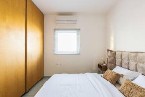 - une chambre avec un lit blanc et une fenêtre dans l'établissement Boho Vibe - Penthouse, à Tel Aviv