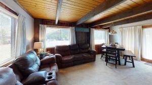 a living room with a leather couch and a table at Aspen Hollow In The Upper Valley With High Speed Wifi in Red River
