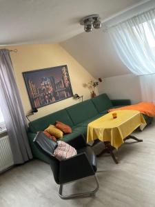 a living room with a green couch and a table at Ferienwohnung-in-Pinnow-bei-Schwerin in Pinnow
