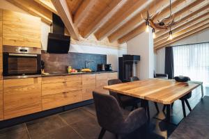 a kitchen with a wooden table and a dining room at Haus Piz Lad in Nauders