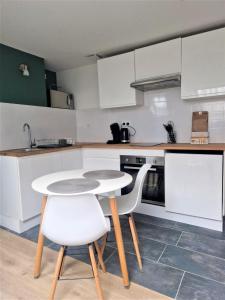 a kitchen with a table and two white chairs at Bel Appartement Hypercentre in Tours