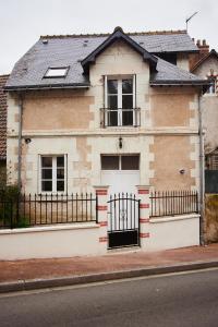 una casa con una puerta y una valla en Gîte l'écurie, en Larçay