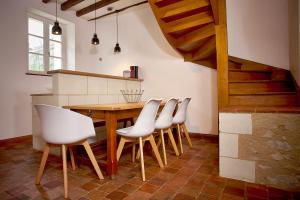 a kitchen with a wooden table and white chairs at Gîte l'écurie in Larçay +5 photos