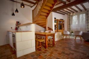 uma cozinha e sala de jantar com uma mesa de madeira em Gîte l'écurie em Larçay