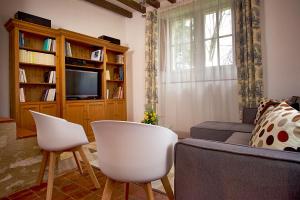 uma sala de estar com um sofá e uma televisão em Gîte l'écurie em Larçay