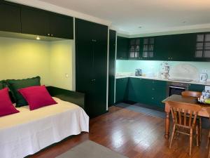 um quarto com armários verdes e uma cama com almofadas vermelhas em Studio by Casa da Quinta no Funchal