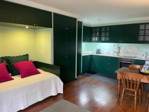a bedroom with green cabinets and a bed with red pillows at Studio by Casa da Quinta in Funchal