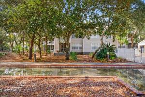 a house with trees and a pond in front of it at Hidden Dunes Beach Cottage 208- Dune Our Thing in Destin