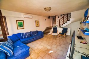 ein Wohnzimmer mit einem blauen Sofa und einem Tisch in der Unterkunft Villa Laura - Putzu Idu in Putzu Idu
