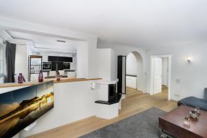 cocina y sala de estar con paredes blancas y suelo de madera en Kitz-Heart Apartments by Alpine Host Helpers en Kitzbühel