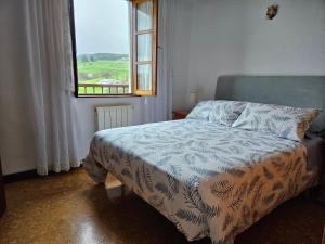 Un dormitorio con una cama y una ventana con vistas. en Casa Blanca Güemes, en Bareyo