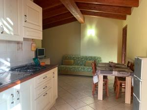 cocina con mesa y sofá en una habitación en Residenza Sophié, en Flumini di Quartu