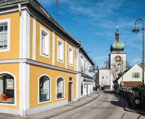 a yellow and white building with a turret on a street at Apartments Zum Ybbsturm in Waidhofen an der Ybbs