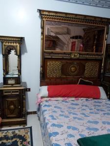 1 dormitorio con 1 cama grande y espejo en الفاوى - القصير, en Quseir