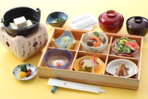 un tavolo con vassoio di cibo e un bollitore per il tè di Hotel Sanderson a Maebashi