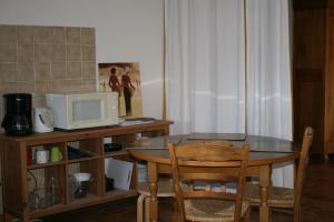 - une cuisine avec une table et un four micro-ondes dans l'établissement Grand Studio en Drôme Provencale, à Vinsobres