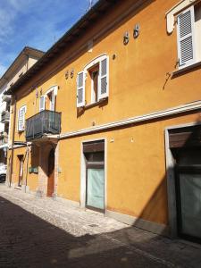 un edificio amarillo con puerta y balcón en 99 Nolfi, en Fano