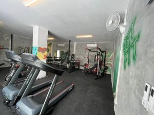 a gym with tread machines and a wall with graffiti at Social Quarters in Railay Beach