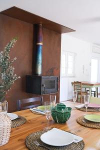 een houten tafel met borden en wijnglazen erop bij The ONE - Country House in Grândola