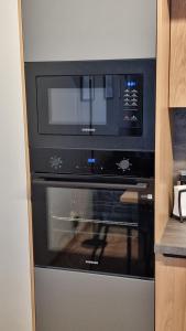 a microwave sitting on top of an oven in a kitchen at Apartament SALONET Airport & MTP in Skórzewo