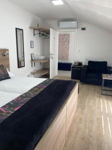 a bedroom with a bed and a living room with a couch at Guesthouse Bebek in Sarajevo