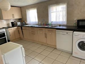 a kitchen with a washer and a sink and a dishwasher at Room only guest accommodation, guest house in Bangor