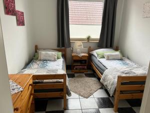 2 Einzelbetten in einem Zimmer mit Fenster in der Unterkunft Im Heidedorf Haus to Baben in Cuxhaven