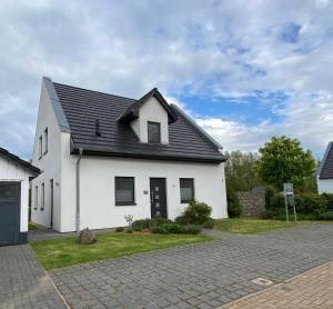 a white house with a black roof at Villa Major in Göhren-Lebbin