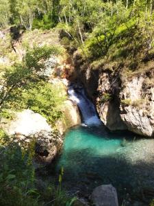 a pool of water in a canyon with a waterfall at Le chalet de Sabine et Patrick in Vicdessos